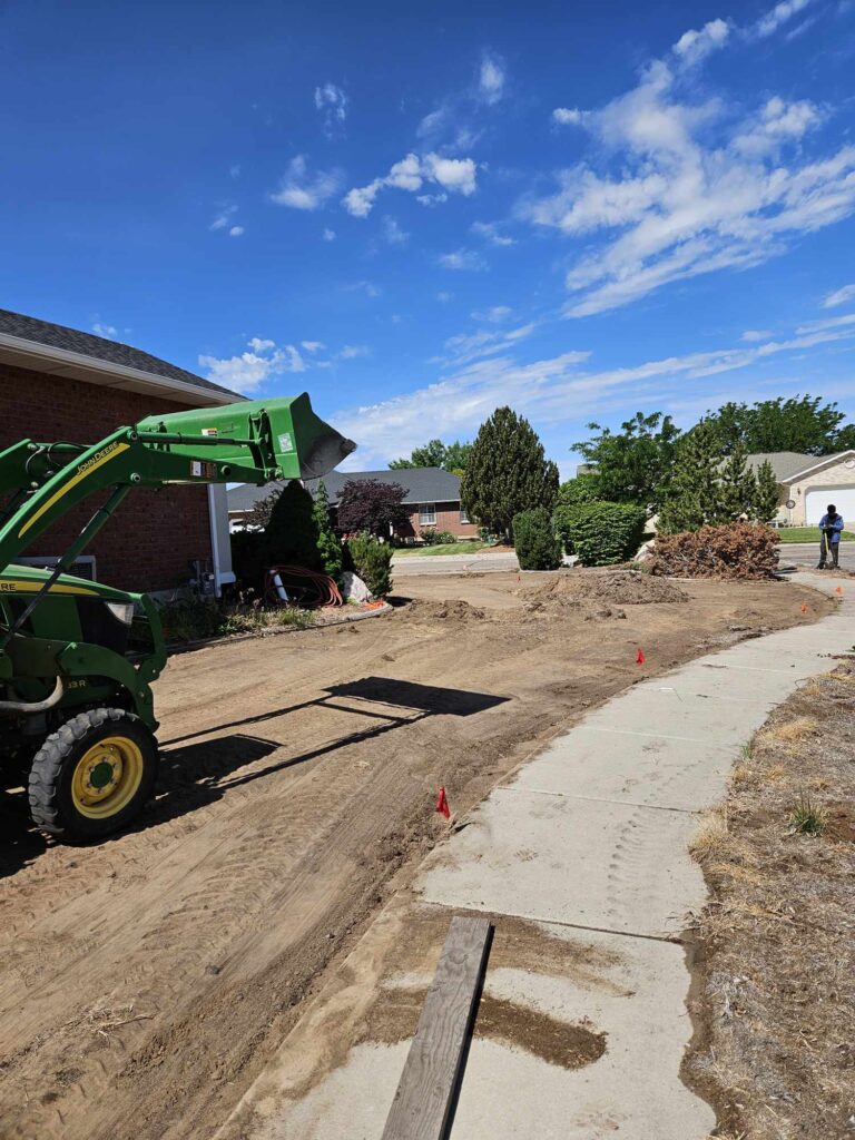 Tractor with scoop up high on packed dirt